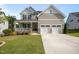 Charming two-story home with a covered front porch, two car garage, and landscaping at 525 Marion Hills Way, Knightdale, NC 27545