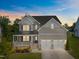 Charming two-story home with a welcoming front porch, stone accents, and a well-manicured lawn under a beautiful sky at 525 Marion Hills Way, Knightdale, NC 27545