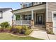 Close-up of the charming front porch with stone detailing, white railing, and manicured landscaping leading to the entrance at 525 Marion Hills Way, Knightdale, NC 27545