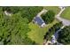 Aerial view of the home with a lush green yard, fenced perimeter, and mature trees at 5413 Lower Creek Ct, Apex, NC 27539