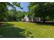 Spacious backyard with lush green grass, mature trees, and outdoor seating area at 5413 Lower Creek Ct, Apex, NC 27539