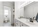 Bright bathroom with a marble countertop, white cabinets, and open shelving for storage at 5413 Lower Creek Ct, Apex, NC 27539
