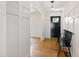 Inviting entryway featuring a black front door, hardwood floors, coat hooks, and paneled walls at 5413 Lower Creek Ct, Apex, NC 27539