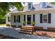 Inviting front entrance with brick steps, potted plants, black shutters, and a black front door at 5413 Lower Creek Ct, Apex, NC 27539