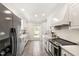 Bright kitchen with white cabinetry, stainless steel appliances, and tile flooring at 5413 Lower Creek Ct, Apex, NC 27539