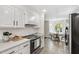 Modern kitchen flows into dining area with white cabinets and stainless steel appliances at 5413 Lower Creek Ct, Apex, NC 27539