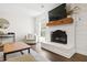 Cozy living room with painted brick fireplace, wood mantle, and modern decor at 5413 Lower Creek Ct, Apex, NC 27539