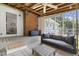 Inviting screened porch with comfortable swing seat, ceiling fan, brick wall and access to the backyard at 5413 Lower Creek Ct, Apex, NC 27539