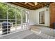 View of the screened porch with white trim, ceiling fan, rug, seating and access to the home's interior at 5413 Lower Creek Ct, Apex, NC 27539