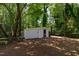 View of backyard storage shed with painted white walls and door on a sunny day at 5413 Lower Creek Ct, Apex, NC 27539