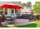Brick patio with outdoor furniture, grill, and lush landscaping for outdoor relaxation at 6004 Brass Tack Ct, Fuquay Varina, NC 27526