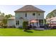 Rear exterior showcasing the home's architecture with a screened porch and brick patio with manicured lawn at 6004 Brass Tack Ct, Fuquay Varina, NC 27526