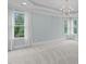 Spacious bedroom with neutral tones, large windows, and an elegant chandelier at 6004 Brass Tack Ct, Fuquay Varina, NC 27526