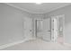 An airy bedroom featuring neutral walls, carpet, and multiple doorways at 6004 Brass Tack Ct, Fuquay Varina, NC 27526