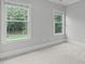 Bright bedroom featuring neutral walls, carpet, and natural light from two windows at 6004 Brass Tack Ct, Fuquay Varina, NC 27526