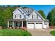Charming two-story home featuring a three-car garage, inviting front porch, and well-maintained landscaping at 6004 Brass Tack Ct, Fuquay Varina, NC 27526