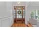 Grand foyer featuring hardwood floors, a decorative front door with glass panels, and white wainscoting at 6004 Brass Tack Ct, Fuquay Varina, NC 27526