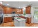 Well-lit kitchen with stainless steel appliances, center island, and hardwood floors at 6004 Brass Tack Ct, Fuquay Varina, NC 27526
