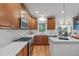 Modern kitchen with custom cabinets, white countertops, hardwood floors, and stainless steel appliances at 6004 Brass Tack Ct, Fuquay Varina, NC 27526