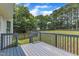 View from deck overlooking large backyard, grass lawn, mature trees, and partial wooden perimeter fence at 6221 Winter Spring Dr, Wake Forest, NC 27587