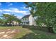 Exterior view of the white house from the backyard with a gray deck, a wooden fence, and mature trees at 6221 Winter Spring Dr, Wake Forest, NC 27587
