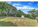 Expansive backyard featuring a well-maintained lawn, a storage shed, mature trees, and a wooden fence at 6221 Winter Spring Dr, Wake Forest, NC 27587