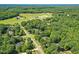 Aerial view of a neighborhood of homes and large green pastures and farms in the distance at 65 Georgetown Woods Dr, Youngsville, NC 27596
