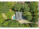 Overhead view of a home surrounded by mature trees with a swimming pool and driveway at 65 Georgetown Woods Dr, Youngsville, NC 27596