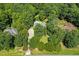 Expansive aerial view of a landscaped home with a swimming pool nestled among mature trees at 65 Georgetown Woods Dr, Youngsville, NC 27596