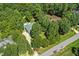 Aerial view of a home nestled among mature trees featuring a backyard swimming pool at 65 Georgetown Woods Dr, Youngsville, NC 27596