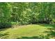 Lush green backyard with space for gardening, mature trees and a view into the woods at 65 Georgetown Woods Dr, Youngsville, NC 27596