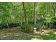 Tranquil backyard with a garden, decorative elements, and surrounding trees for privacy at 65 Georgetown Woods Dr, Youngsville, NC 27596