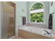 Serene bathroom with a soaking tub, separate shower, and a large window for natural light at 65 Georgetown Woods Dr, Youngsville, NC 27596