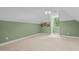 Spacious bedroom with neutral carpet, green walls, and a window overlooking the landscape at 65 Georgetown Woods Dr, Youngsville, NC 27596