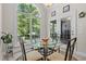 Bright breakfast nook features a glass table, chairs, and large windows offering backyard views at 65 Georgetown Woods Dr, Youngsville, NC 27596
