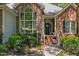 Charming brick home featuring a front porch with decorative plants and a classic wreath on the front door at 65 Georgetown Woods Dr, Youngsville, NC 27596