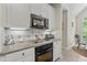Kitchen features white cabinetry, granite countertops, stainless steel appliances and tile backsplash at 65 Georgetown Woods Dr, Youngsville, NC 27596