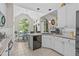 Open kitchen with white cabinets, granite countertops, and dining area overlooking backyard at 65 Georgetown Woods Dr, Youngsville, NC 27596