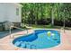 Inviting private pool with a concrete deck surrounded by mature trees at 65 Georgetown Woods Dr, Youngsville, NC 27596