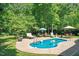 Inviting backyard pool featuring lounge chairs, mature trees and ample space for entertaining at 65 Georgetown Woods Dr, Youngsville, NC 27596