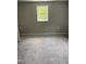 Cozy bedroom features soft carpet and a window offering natural light and backyard view at 713 Champion St, Henderson, NC 27536
