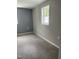 Cozy bedroom featuring light gray walls, plush carpet, and a window offering natural light at 713 Champion St, Henderson, NC 27536