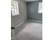 Bright bedroom with plush carpet, neutral walls, and windows providing plenty of natural light at 713 Champion St, Henderson, NC 27536