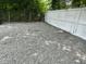 Gravel driveway with white fence surrounded by trees and providing ample parking at 713 Champion St, Henderson, NC 27536