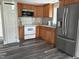 Well-lit kitchen featuring wood cabinets, stainless steel refrigerator, and modern appliances at 713 Champion St, Henderson, NC 27536