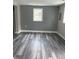 Spacious room featuring stylish vinyl floors, modern paint, and a window for natural light at 713 Champion St, Henderson, NC 27536