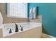 This bathroom boasts a soaking tub with bronze fixtures and a beautiful teal accent wall at 732 Keystone Park Dr, Morrisville, NC 27560