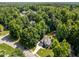 Aerial view of a neighborhood showcasing homes nestled among mature trees, featuring well-maintained lawns and landscaping at 7605 Pats Branch Dr, Raleigh, NC 27612