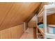 Attic storage area with sloped ceilings, wood paneling, and shelving at 7605 Pats Branch Dr, Raleigh, NC 27612