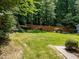 Wide angle of the expansive, freshly cut back yard with a stained wood privacy fence and trees at 7605 Pats Branch Dr, Raleigh, NC 27612